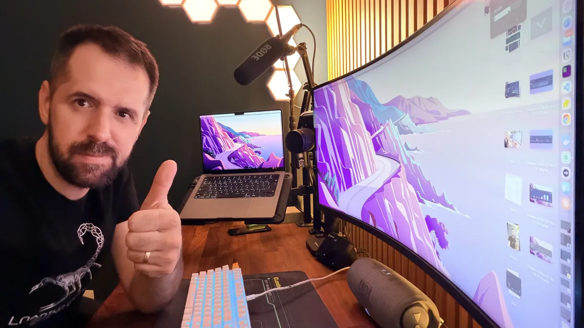 Eusebiu, the solo founder of loggd.life, giving a thumbs up at his desk with a laptop and ultrawide monitor showing the app.